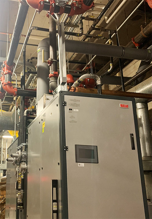 Commercial boiler equipment with piping and mechanical systems installed in a boiler room.